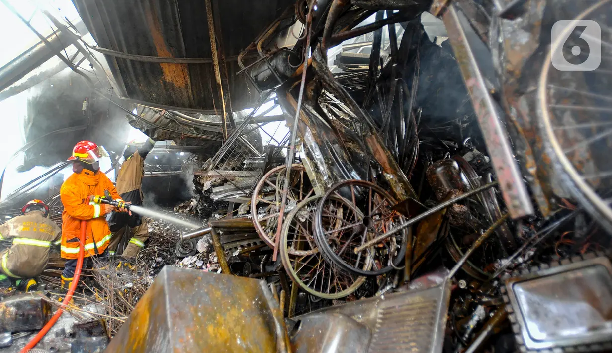 Petugas pemadam kebakaran Pemerintah Kota Depok memadamkan sisa api kebakaran lapak rongsok di Jalan Karet, Beji, Kota Depok, Jawa Barat, Selasa (5/12/2023). Sekitar 10 unit mobil pemadam kebakaran dikerahkan untuk memadamkan kebakaran yang terjadi di belakang Margo City tersebut. (merdeka.com/Arie Basuki)
