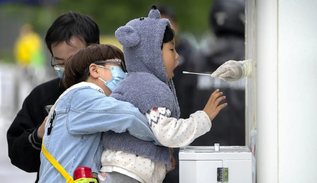 <p>Seorang anak melakukan usap tenggorokan untuk tes COVID-19 di sebuah tempat pengujian di Beijing, Kamis (28/4/2022). Beijing mengalihkan lebih banyak kelas secara online pada hari Kamis dalam pengetatan pembatasan COVID-19 lebih lanjut, karena ibu kota China berupaya mencegah penyebaran yang lebih luas. (AP Photo/Mark Schiefelbein)</p>