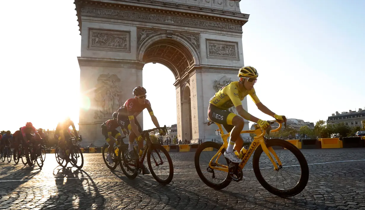 Pebalap Kolombia Egan Bernal (kanan) melewati Arc de Triomphe saat mengikuti Tour de France 2019, Paris, Prancis, Minggu (28/7/2019 ). Egan Bernal memenangkan Tour de France 2019 setelah masuk Kota Paris dengan memimpin klasemen keseluruhan. (Julien de Rosa/ Thibault Camus)