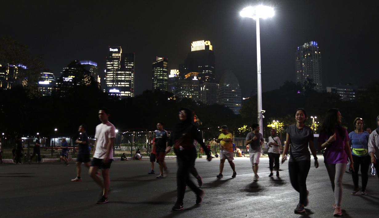 Sejumlah warga berlari di kawasan Stadion Utama Gelora Bung Karno, Senayan, Jakarta, Rabu (9/10). Olahraga lari pada malam hari di GBK menjadi pilihan pekerja ibu kota. (Bola.com/Yoppy Renato)