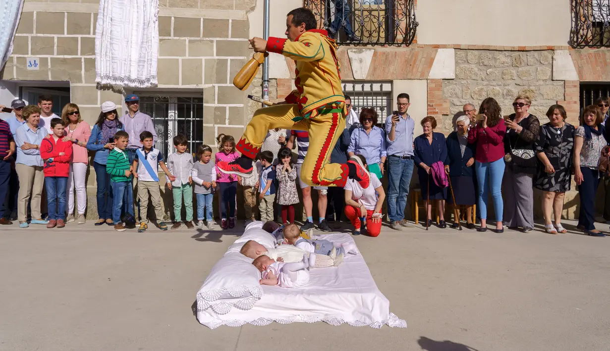 Pria berkostum setan melompati bayi-bayi yang diletakkan di atas matras selama tradisi El Salto del Colacho di desa Castrillo de Murcia, Spanyol, Minggu (3/6). Festival melompati bayi ini sudah menjadi perayaan tahunan sejak 1620 (afp/CESAR MANSO)