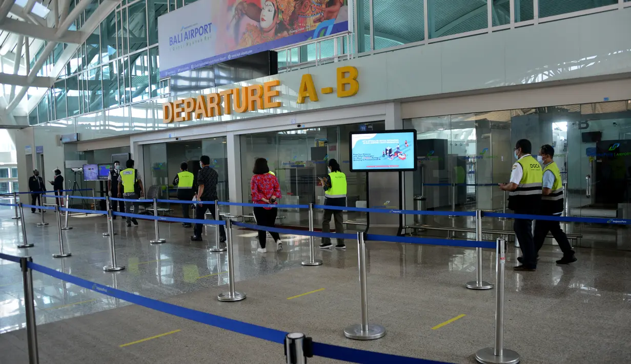 <p>Petugas bandara berjalan di area keberangkatan internasional di bandara Ngurah Rai di Tuban dekat Denpasar di pulau resor Bali (5/10/2021). Bandara Ngurah Rai akan kembali dibukan pada 14 Oktober untuk beberapa pelancong internasional. (AFP/Sony Tumbelaka)</p>
