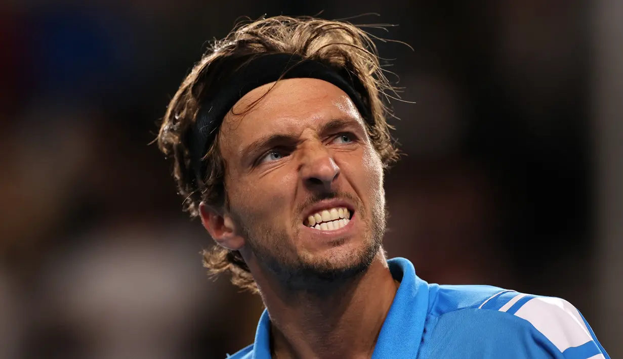 Arthur Rinderknech dari Prancis bereaksi ketika melawan petenis Australia Alexei Popyrin dari Australia dalam pertandingan tunggal putra mereka pada hari kedua turnamen tenis Australia Open di Melbourne, 18 Januari 2022. (Martin KEEP / AFP)