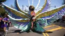 Seorang penari mengenakan kostum bulu selama ambil bagian dalam Parade West Indian Day di Brooklyn borough, New York, Senin (4/9). Parade tersebut merupakan salah satu perayaan budaya Karibia terbesar di Amerika Serikat. (AP Photo/Kevin Hagen)