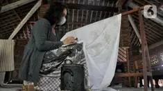 Rita saat menyelesaikan pembuatan batik tulis Lumbini di Dusun Tingal, Desa Wanurejo, Kecamatan Borobudur, Kabupaten Magelang, Jawa Tengah, Selasa (17/5/2022). Pasangan suami istri Adiwinarto (56) dan Rita (53) merintis batik tulis Lumbini pada 2011. (merdeka.com/Iqbal S. Nugroho)