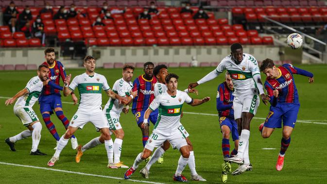 Penyerang Barcelona, Francisco Trincao dan gelendang Elche, Omenuke Mfulum melompat saat berebut bola pada lanjutan Liga Spanyol di Camp Nou, Kamis (25/2/2021) dini hari WIB. Barcelona menang 3-0 melalui dua gol yang dicetak Lionel Messi dan satu gol lagi dicetak Jordi Alba. (AP Photo/Joan Monfort)