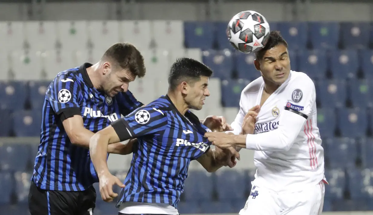 Gelandang Real Madrid, Casemiro (kanan) berebut bola di udara dengan dua pemain Atalanta, Cristian Romero (tengah) dan Berat Djimsiti dalam laga leg pertama babak 16 Besar Liga Champions 2020/21 di Gewiss Stadium, Bergamo, Rabu (24/2/2021). Real Madrid menang 1-0 atas Atalanta. (AP/Luca Bruno)