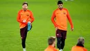 Penyerang Barcelona, Lionel Messi dan Luis Suarez melakukan pemanasan saat mengikuti sesi latihan di stadion Stamford Bridge di London, (19/2). Barcelona akan menghadapi Chelsea pada babak 16 besar Liga Champions. (AP Photo/Alastair Grant)