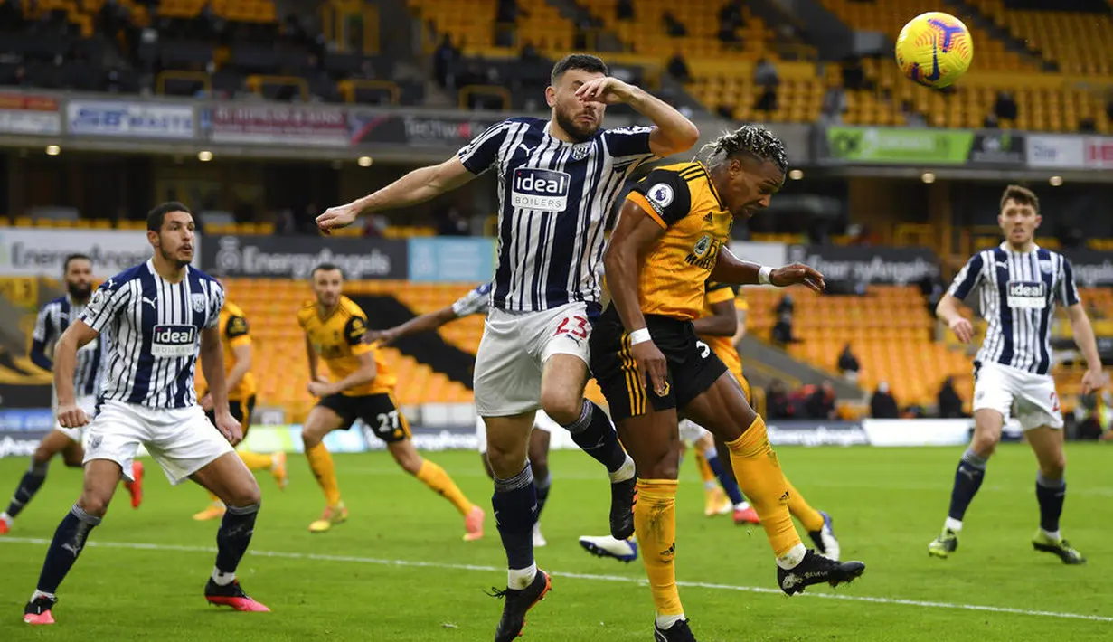 Striker Wolverhampton Wanderers, Adama Traore, berebut bola dengan pemain West Bromwich Albion, Robert Snodgrass, pada laga Liga Inggris di Stadion Molineux, Sabtu (16/1/2021). Wolves takluk dengan skor 2-3. (Shaun Botterill/Pool via AP)
