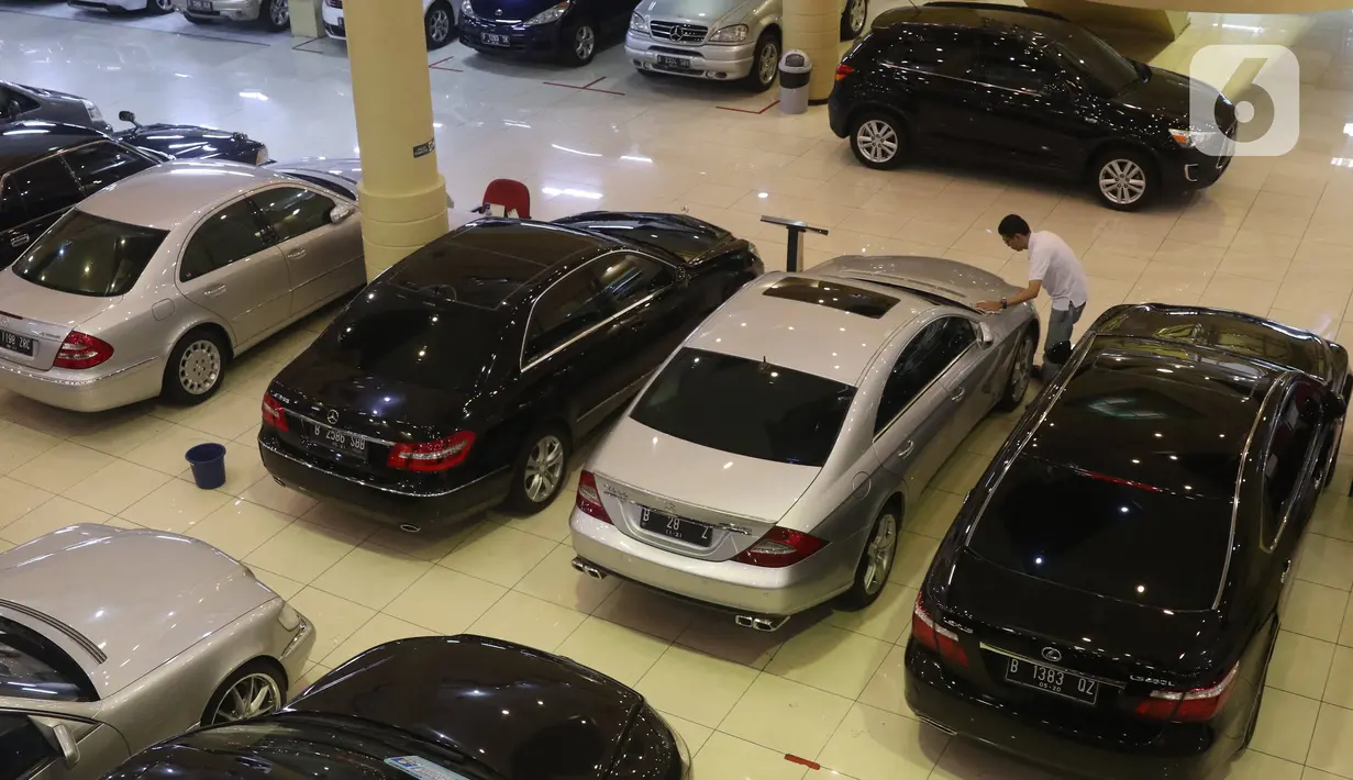 Pedagang mengelap mobil bekas yang dijual di Jakarta, Senin (24/2/2020). Realisasi penjualan mobil bekas pada Januari 2020 mencapai 2.100-an unit, menurun 8,69 persen dibandingkan penjualan pada Januari 2019 yang mencapai 2.300 unit. (Liputan6.com/Angga Yuniar)