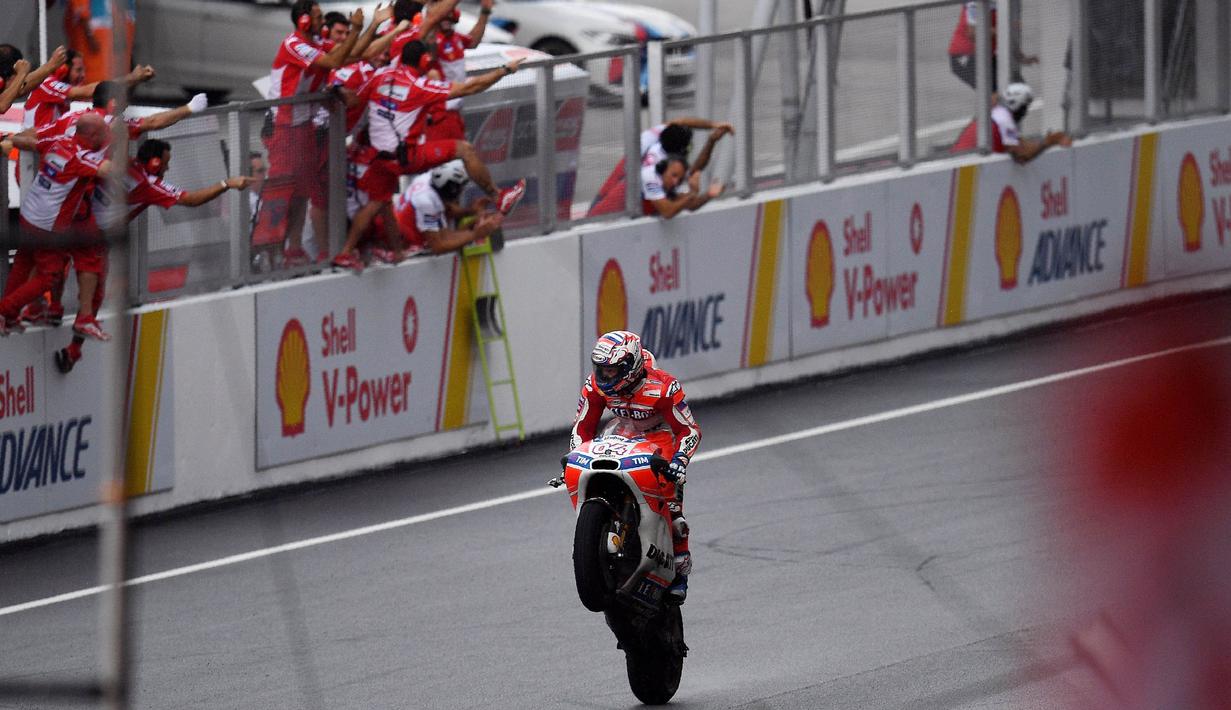 Pebalap Ducati, Andrea Dovizioso, melakukan selebrasi usai menjuarai balapan MotoGP Malaysia di Sirkuit Sepang, Minggu (29/10/2017). Dovizioso finis pertama dengan catatan waktu 44 menit 51,497 detik. (AFP/Manan Vatsyayana)