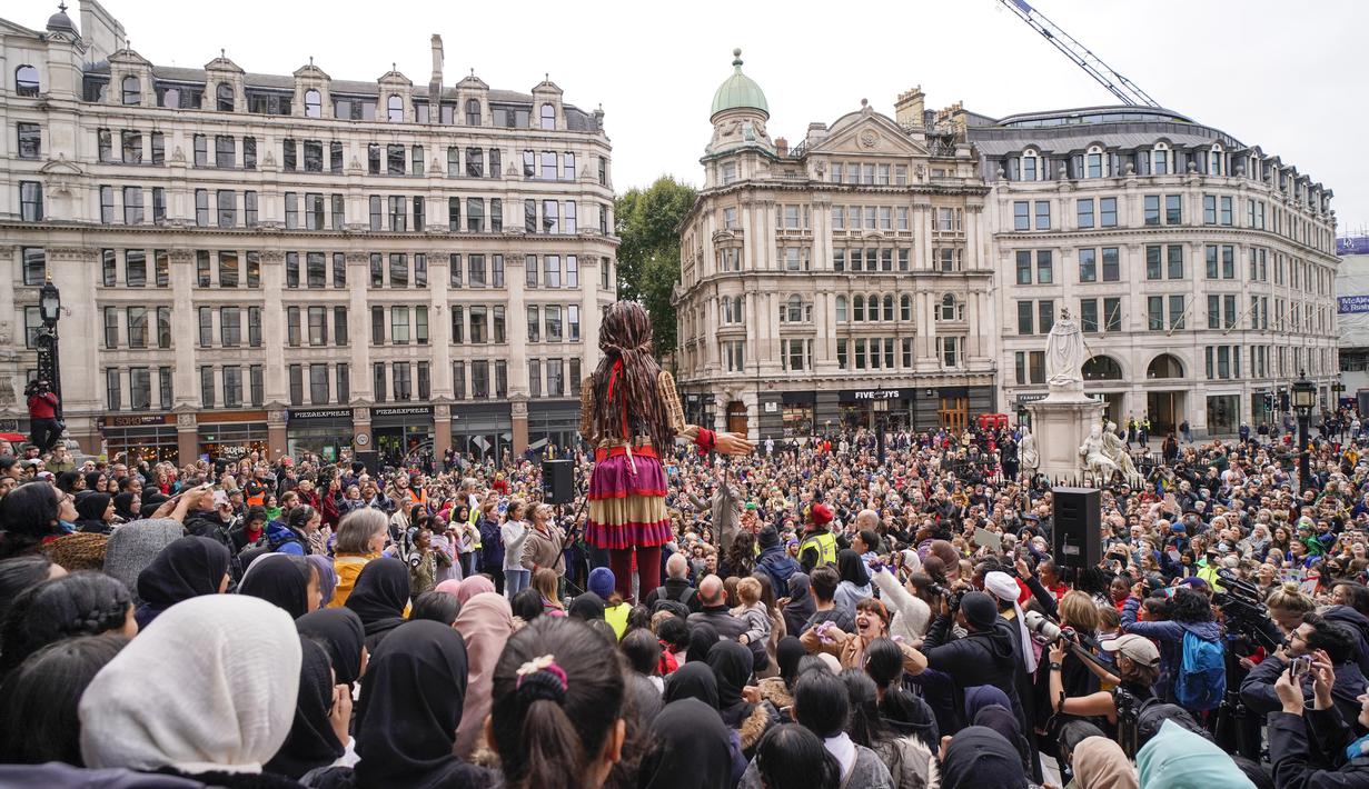 Boneka raksasa Little Amal disambut ratusan warga saat tiba di kota London, Inggris, Sabtu (23/10/2021). Little Amal merupakan bagian dari proyek 'The Walk', sebuah inisiatif seni. (AP Photo/Alberto Pezzali)