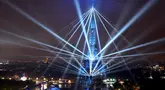 Pemandangan Menara Eiffel dan laser yang menerangi langit, selama upacara pembukaan Olimpiade Paris 2024, Jumat (26/7/2024). (Cheng Min / POOL / AFP)