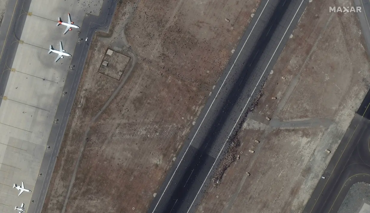 Foto satelit menunjukkan segerombolan orang di landasan di Bandara Internasional Kabul, juga dikenal sebagai Bandara Internasional Hamid Karzai, Senin (16/8/2021). (Satellite image ©2021 Maxar Technologies via AP)