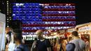 Warga melintas di dekat balai kota Tel Aviv yang dihiasi warna bendera AS untuk menghormati korban penembakan brutal di Las Vegas di Rabin Square, Tel Aviv (2/10). Pelaku penembakan diketahui bernama Stephen Paddock 64 tahun. (AFP Photo/Jack Guez)