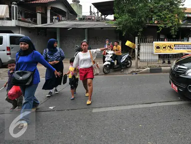 Pejalan kaki menyeberang meski terdapat tulisan agar tidak menyeberang sembarangan di jalan raya Lenteng Agung, Jakarta (3/12). Ironisnya, tak jauh dari lokasi terdapat Jembatan Penyeberangan Orang (JPO) yang masih berfungsi. (Liputan6.com/Yoppy Renato)
