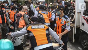 Petugas gabungan yang terdiri dari Satpol PP dan Dinas Perhubungan (Dishub) DKI Jakarta mengangkut motor yang terjaring razia ke atas truk di lokasi Citayam Fashion Week, kawasan Stasiun Dukuh Atas, Sudirman, Selasa (26/7/2022). Dishub DKI Jakarta mengamankan sebanyak 16 sepeda motor yang terpakir secara liar. (Liputan6.com/Faizal Fanani)