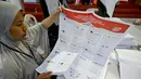 Para staf melipat surat suara pemilihan umum Indonesia 2024 di Gudang Logistik Komisi Pemilihan Umum (KPU) Denpasar, Bali, pada 14 Desember 2023. (SONNY TUMBELAKA/AFP)