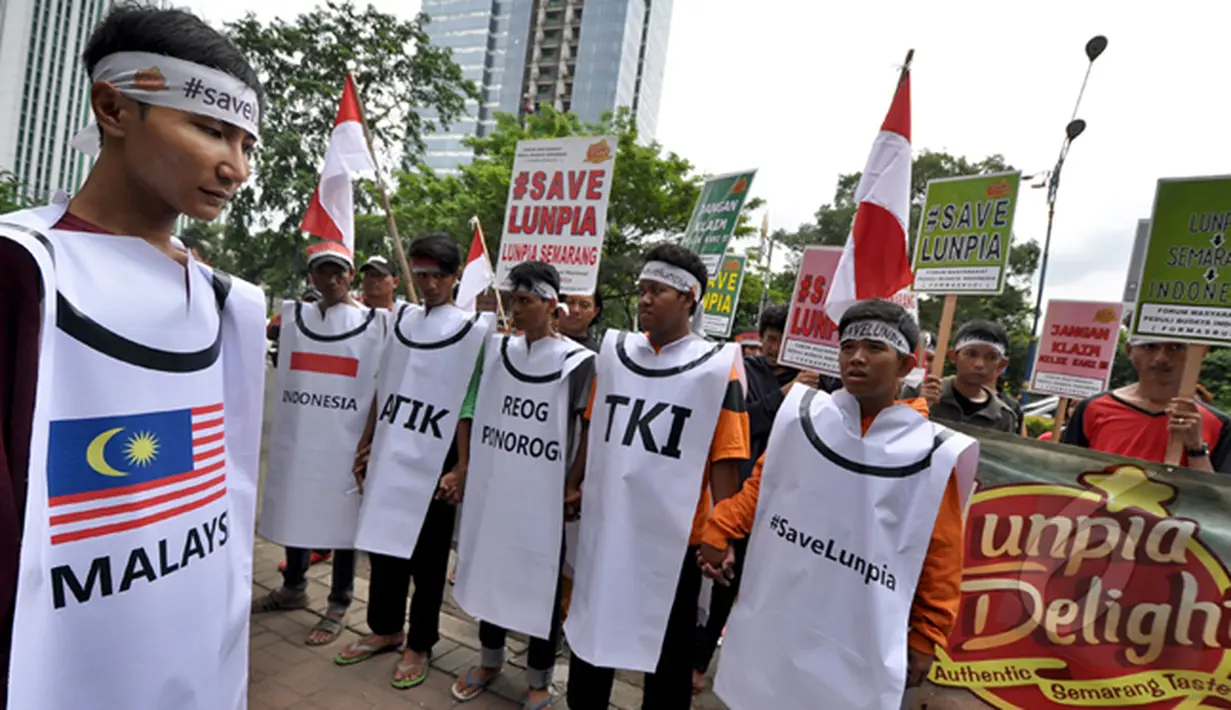 Sejumlah aktivis berpegangan tangan dalam aksinya di depan Kedutaan Besar Malaysia, Jakarta (20/2/2015). ). Aktivis Semarang menggelar aksi memprotes makanan khas Kota Semarang Lumpia yang diklaim sebagai produk Malaysia. (Liputan6.com/Faizal Fanani)