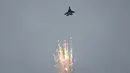Jet tempur F-15SG dari Angkatan Udara Republik Singapura melakukan manuver di udara sambil mengeluarkan flair jelang Singapore Airshow 2018, Jumat (2/2). (AP Photo/Wong Maye-E)