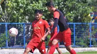 Gelandang Arema, Jayus Hariono dan Dave Mustaine berebut bola dalam sesi latihan. (Bola.com/Iwan Setiawan)