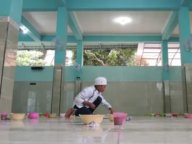 Pengurus Masjid Pekojan menyiapkan bubur India untuk menu buka puasa di serambi masjid, Semarang, Jawa Tengah, Kamis (17/5 ). Bubur India sebagai menu berbuka puasa di masjid ini sudah berjalan seabad lalu. (Liputan6.com/Gholib)