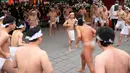 <p>Jemaat yang setengah telanjang melakukan pemanasan sebelum menyiram diri mereka dengan air dingin saat ritual ketahanan dingin di Kuil Shinto Kanda Myojin, Tokyo, Jepang, Sabtu (14/1/2023). Dalam ritual yang berlangsung selama dua hari dan menjadi bagian dari festival Shinto itu peserta menuangkan air dingin ke tubuh karena diyakini dapat menyucikan jiwa mereka. (AP Photo/Hiro Komae)</p>