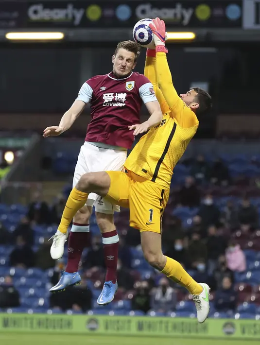 Kiper Liverpool, Alisson melakukan penyelamatan dari penyerang Burnley, Chris Wood pada pekan ke-37 Liga Inggris di Stadion Turf Moor, Kamis (20/5/2021) dini hari WIB. Liverpool sukses menembus empat besar klasemen Liga Inggris setelah menang telak 3-0 atas Burnley. (Martin Rickett/Pool via AP)