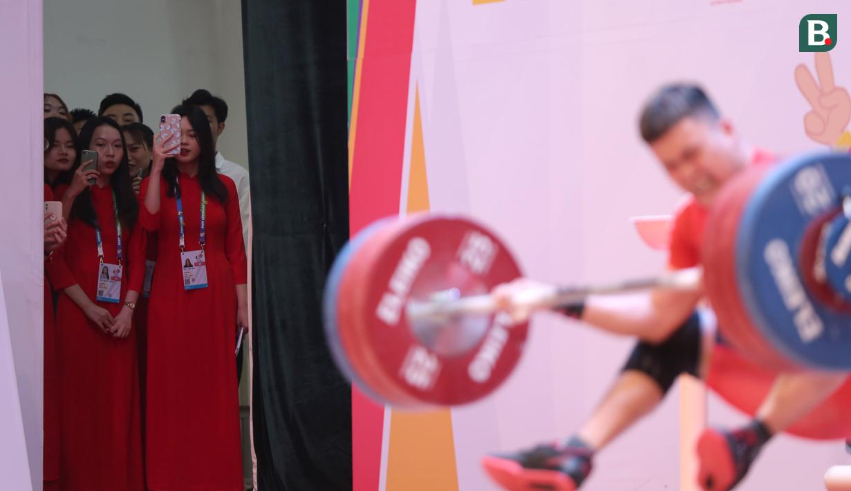 Dengan gadget di genggaman para wanita bergaun merah ini pun dengan leluasa mengabadikan aksi-aksi para lifter di kelas 73 kg putra ini berlomba. (Bola.com/Ikhwan Yanuar)