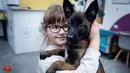 Nastya (9) memeluk seekor anjing bernama Barcelona selama sesi terapi anjing di Kyiv, Ukraina, Kamis, 26 Oktober 2023.