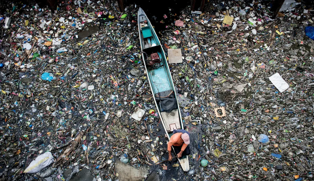 Seorang pekerja mengumpulkan sampah dari Sungai Marilao di Bulacan, sebelah utara Manila, 18 Maret 2017. Sungai di Filipina ini disebut sebagai salah satu 30 tempat terkotor di dunia. (Noel CELIS/AFP)