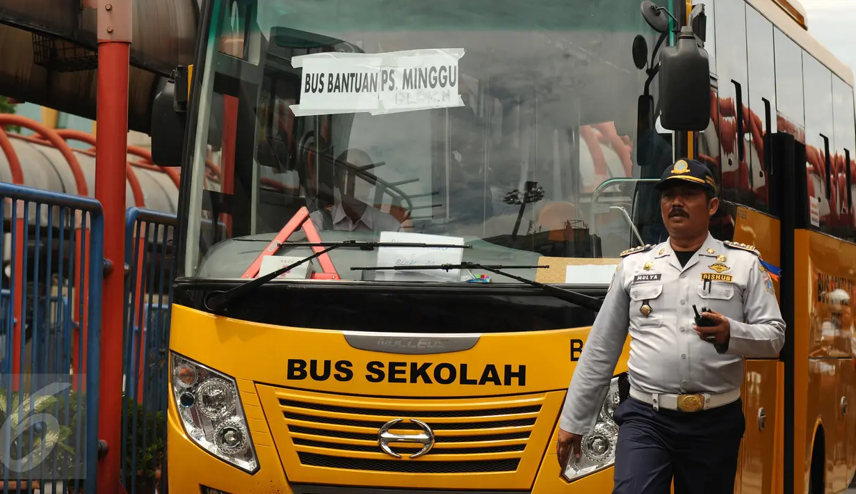 Petugas mengawal bus sekolah untuk mengangkut penumpang di Terminal Blok M Jakarta, Senin (21/12/2015). Bus sekolah dikerahkan untuk mengantisipasi penumpukan penumpang seiring mogoknya sejumlah sopir metromini. (Liputan6.com/Helmi Fithriansyah)