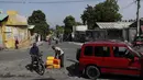 Seorang pria membeli bahan bakar dari sepeda motornya di sebuah jalan di Port-au-Prince, empat hari setelah pembunuhan Presiden Haiti Jovenel Moise, Minggu (11/7/2021). Sebelumnya, Moise tewas dibunuh dalam serangan di kediaman pribadinya, pada Rabu 7 Juli 2021 dini hari. (AP Photo / Fernando Llano)