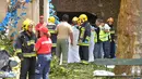 Petugas pemadam kebakaran setempat mengevakuasi korban pohon tumbang di Funchal, Portugal (15/8). Sedikitnya 11 orang tewas akibat tertimpa pohon tumbang tepat ketika berlangsung festival keagamaan. (AFP Photo/Rui Silva)