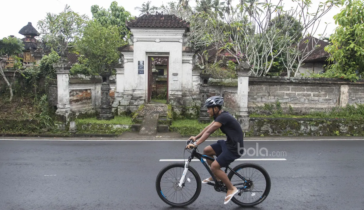 Striker Timnas Indonesia U-22, Ahmad Nur Hardianto, bersepada melintasi sebuah pura di Ubud, Bali, Jumat (7/7/2017). Penyerang Persela ini sedang mengikuti pemusatan latihan jelang SEA Games. (Bola.com/Vitalis Yogi Trisna)
