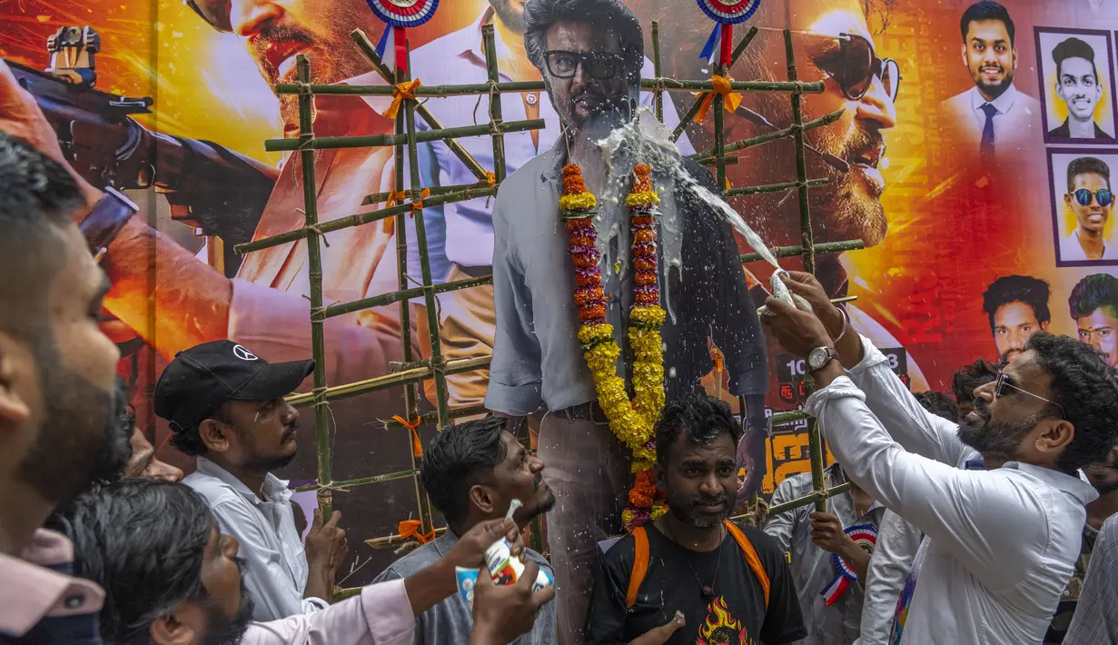 Para penggemar India menyiramkan susu ke potongan gambar superstar mereka, Rajinikanth, di luar gedung bioskop saat merayakan pemutaran film terbarunya "Jailer" di Mumbai, India, Kamis, 10 Agustus 2023. (AP Photo/Rafiq Maqbool)