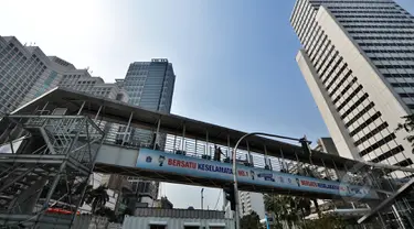 Sejumlah orang menyeberang melalui Jembatan Penyeberangan Orang (JPO)  Bundaran HI, Jakarta, Jumat (20/3/2015). Pemprov DKI akan menjadikan JPO di kawasan Bundaran HI sebagai standar JPO yang ada di Jakarta nanti. (Liputan6.com/Faizal Fanani)