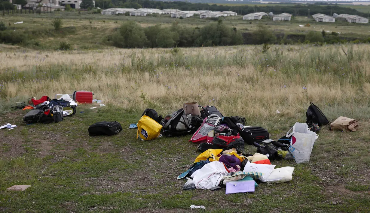 Tas dan koper milik penumpang MH17 tampak berserakan dilokasi jatuhnya pesawat di wilayah Donetsk, Ukraina, Jumat (18/7/14). (REUTERS/Maxim Zmeyev)