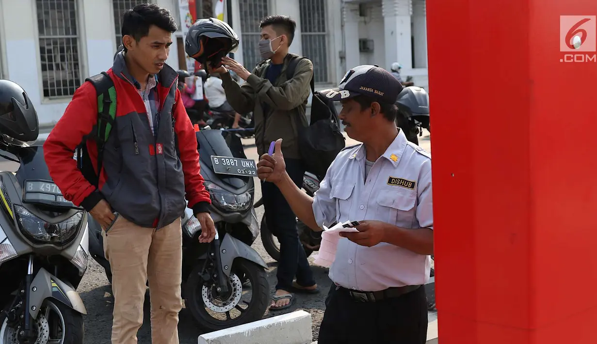 Petugas berjaga di depan mesin parkir meter di kawasan Kota Tua, Jakarta, Rabu (18/7). Sebanyak 13 Terminal Parkir Elektronik (TPE) dipasang di kawasan tersebut guna mengantisipasi membludaknya kendaraan yang parkir. (Liputan6.com/Immanuel Antonius)