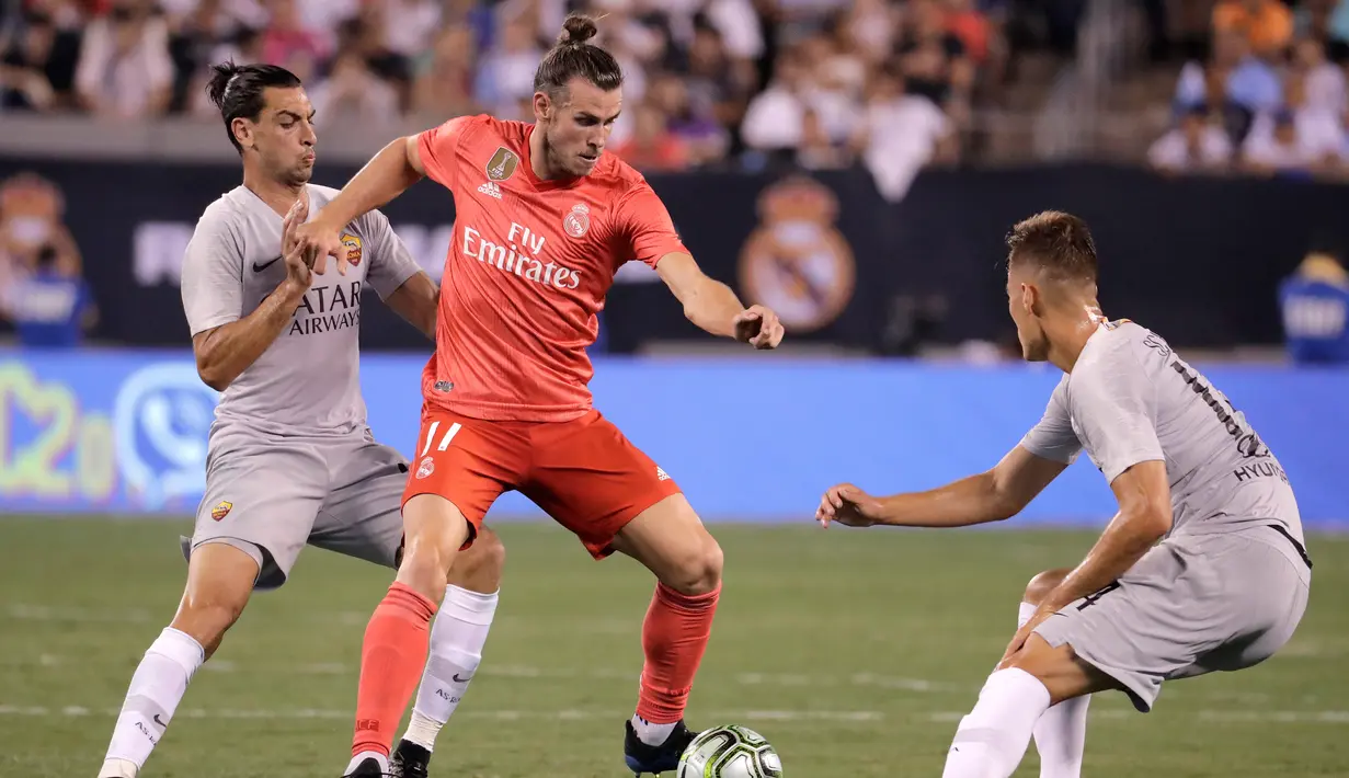 Pemain depan Real Madrid, Gareth Bale (tengah) mempertahankan bola saat berhadapan dengan gelandang AS Roma Javier Pastore (kiri) dan Patrik Schick (kanan) dalam International Champions Cup (ICC) di New Jersey, AS, Selasa (7/8). (AP Photo/Julio Cortez)