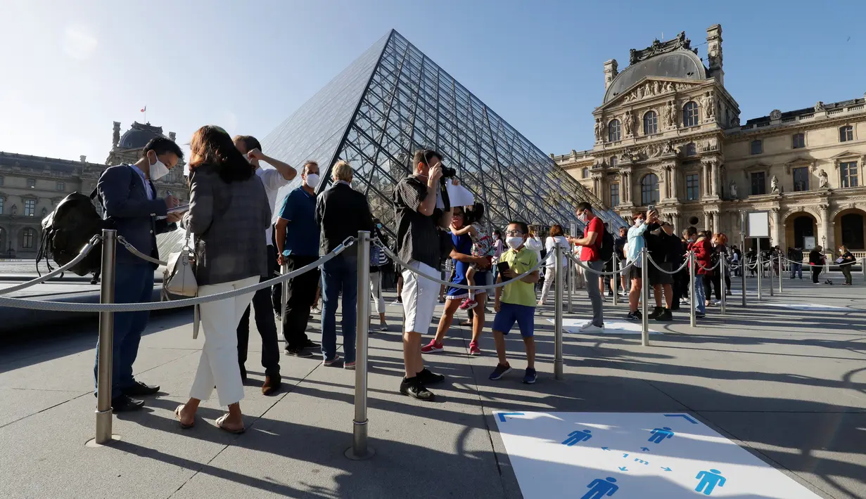 Pengunjung mengentre di piramida Louvre yang dirancang arsitek China Ieoh Ming Pei, pintu masuk ke Museum Louvre pada hari pertama pembukaan di Paris (6/7/2020). Setelah berbulan-bulan ditutup akibat lockdown Covid-19, Museum Louvre  kembali dibuka pada 6 Juli 2020. (AFP/Francois Guillot)