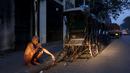 Seorang pria sikat gigi dengan ranting neem di samping deretan becak di Kolkata, 12 Maret 2016. Badan Pusat Statistik India mencatat sebanyak 360 juta rakyat di negeri itu hidup di bawah garis kemiskinan, salah satunya Kolkata (REUTERS/Rupak De Chowdhuri)