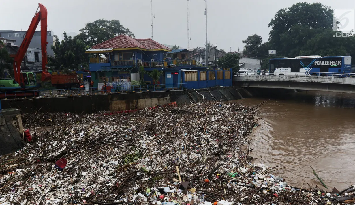 Bus Transjakarta melintasi tumpukan sampah di Pintu Air Manggarai, Jakarta, Rabu (24/4). Tingginya curah hujan di Bogor membuat sampah yang berasal kebanyakan dari sampah rumah tangga ini terbawa arus sungai menumpuk di Pintu Air Manggarai. (Liputan6.com/Johan Tallo)