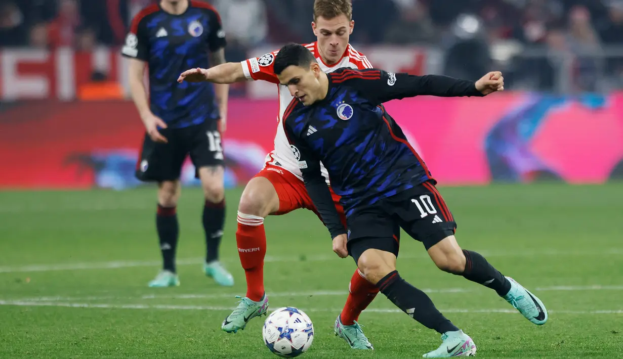 Gelandang Bayern Munchen #06 Joshua Kimmich (tengah) berebut bola dengan penyerang FC Copenhagen #10 Mohamed Elyounoussi pada laga matchday kelima Grup A Liga Champions di Allianz Arena, Kamis (30/12) dini hari WIB. (MICHAELA REHLE / AFP)