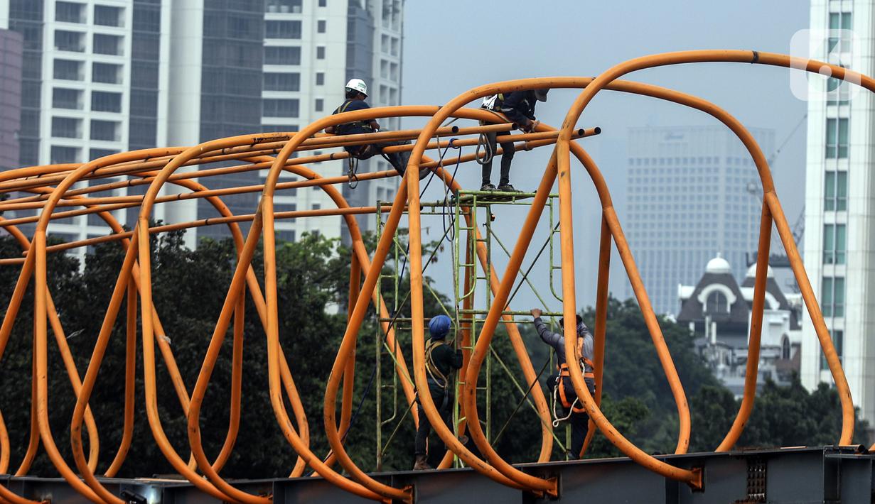 Aktivitas pekerja saat menyelesaikan pembangunan Sky Walk Kebayoran Lama, Jakarta, Selasa (11/10/2022). Jembatan penyebrangan orang (skywalk) ini dibangun untuk mendukung integrasi antarmoda transportasi. (Liputan6.com/JohanTallo)