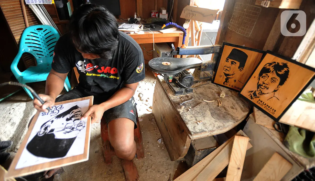 Perajin menyelesaikan pembuatan kerajinan siluet kayu dari wajah tokoh nasional di kawasan Jalan Limo Raya, Depok, Rabu (20/11/2019). Siluet yang terbuat dari kayu limbah industri ini dijual dengan harga Rp 200 ribu hingga Rp 500 ribu dan dikerjakan sesuai foto dari pemesan (merdeka.com/Arie Basuki)
