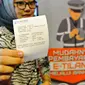 Seorang wanita menunjukkan bukti pembayaran denda tilang dengan tilang online atau e-tilang melalui mesin ATM BRI di Jakarta, Jumat (16/12). Pembayaran elektronik ini sekaligus diklaim bisa menghilangkan praktik percaloan. (Liputan6.com/Angga Yuniar)
