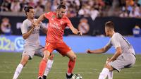 Pemain depan Real Madrid, Gareth Bale (tengah) mempertahankan bola saat berhadapan dengan gelandang AS Roma Javier Pastore (kiri) dan Patrik Schick (kanan) dalam International Champions Cup (ICC) di New Jersey, AS, Selasa (7/8). (AP Photo/Julio Cortez)