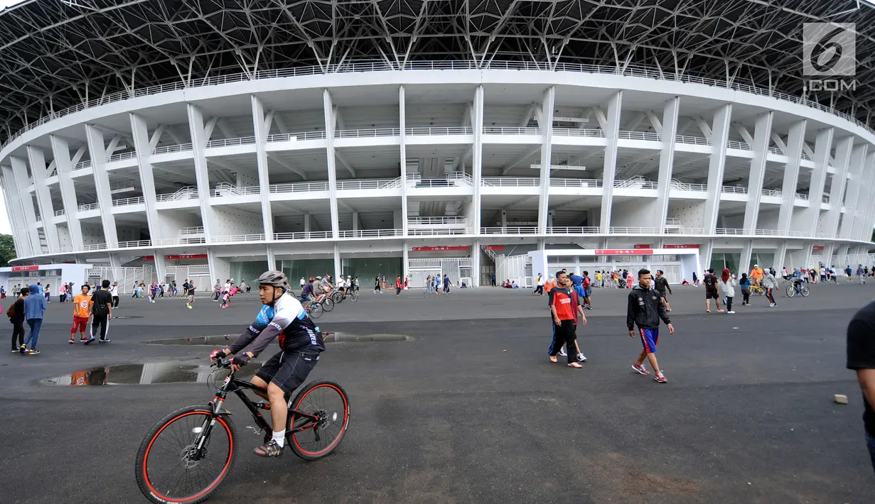 Warga bersepeda melintasi kawasan lingkar luar Stadion Gelora Bung Karno (GBK), Jakarta, Minggu (21/1). Pascarenovasi, kawasan sekitar Stadion GBK kembali dipadati warga yang berolahraga. (Liputan6.com/Helmi Fithransyah)