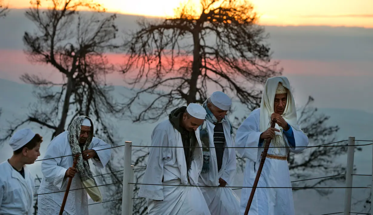 Kaum Samaritan berjalan menuju puncak Gunung Gerizim untuk melakukan doa dalam perayaan hari Sukkot di Israel (4/10). (AFP Photo/Jaafar Ashtiyeh)
